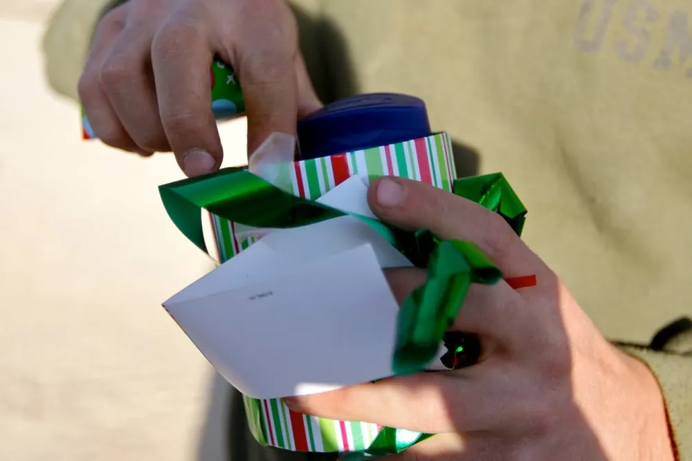 Hands opening a wrapped Secret Santa gift