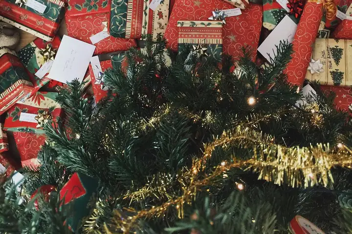 Wrapped Christmas presents piled under a decorated tree